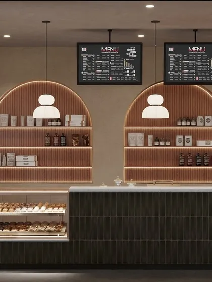 A cafe's counter is its engine. We designed this service area to be both beautiful and highly functional, with arched back-lit shelving for display, clear digital menu boards, and an efficient workflow for staff. The dark green tiles and warm wood tones continue the cafe's modern, earthy aesthetic.