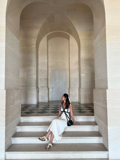 Sitting on the steps inside the Palace of Versailles. The clean lines of the architecture contrast beautifully with the soft silhouette of my white and black lace dress.