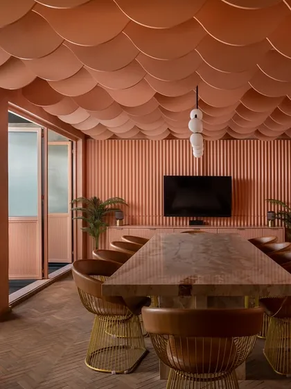 This private lounge is wrapped in a continuous wash of peach tones, from the fluted walls to the scalloped ceiling. The design creates a soft, feminine, and cinematic calm, a quiet escape that uses monolithic color and gentle curves to shape an intimate and memorable experience.