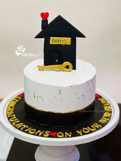 A 'House Warming' themed cake to celebrate a new home. The design features a simple house with a golden key, symbolizing new beginnings and happy memories.