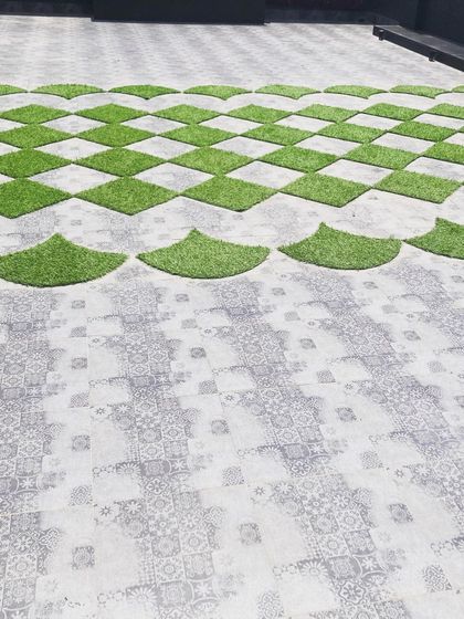 A detailed look at the custom flooring I designed for a large terrace. The pattern combines large format printed tiles with precisely cut artificial grass squares and semi-circles, turning the floor itself into a design feature.