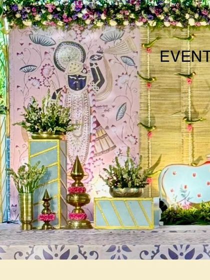 A side view of the naming ceremony stage, showing the hand-painted backdrop details and decorative props. The theme is carried through every element, including brass lamps and cow figurines.