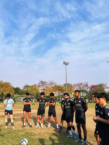 To be at the top, we have to climb every day. Our senior players listening intently to a coach during a training session, focused on continuous improvement.