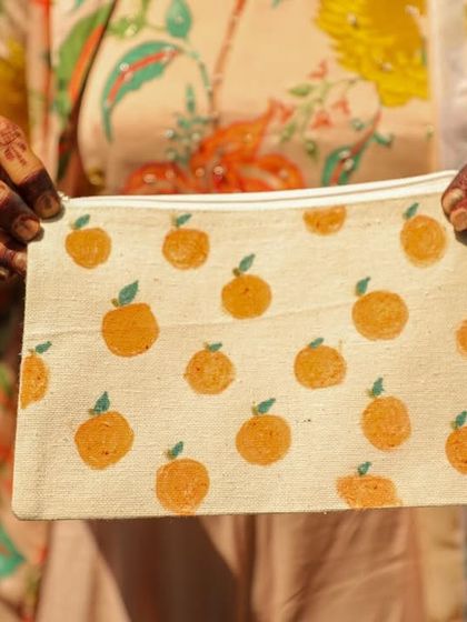 A guest showing off a hand-painted pouch from a DIY wedding event. I provide various items for guests to customize.