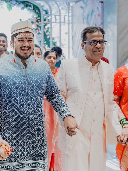 The groom's proud entrance, holding hands with his parents. We believe in capturing the family bonds that are at the heart of every wedding.