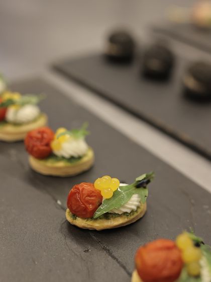 A line of delicate appetizers, ready to be served, highlighting the consistency and quality of our catering.