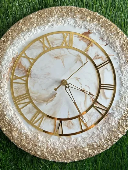 A luxurious clock with a full border of textured gold leaf and crystals, framing a soft marble center.