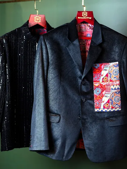 A showcase of our evening wear jackets. This pairing includes a black sequined jacket and a textured black suit with a vibrant, artistic pocket square, built for men who value detail.