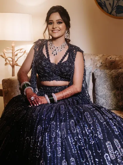 A glamorous ponytail for a Sangeet night, with a teased crown for volume and soft waves through the lengths, paired with a bold blue eyeliner.