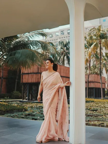A beautiful environmental shot of Kajol in the pink saree, with the lush green background making the color pop.