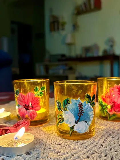 These tinted glass candle holders have been painted with beautiful hibiscus and peony flowers, creating a warm, floral glow.