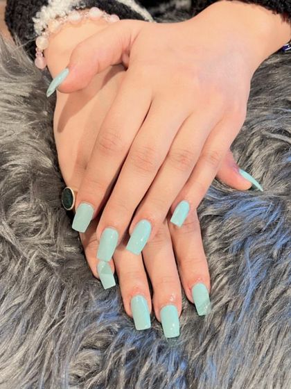 A lovely pastel mint green polish on square-shaped nails. This is a great color for spring and summer.