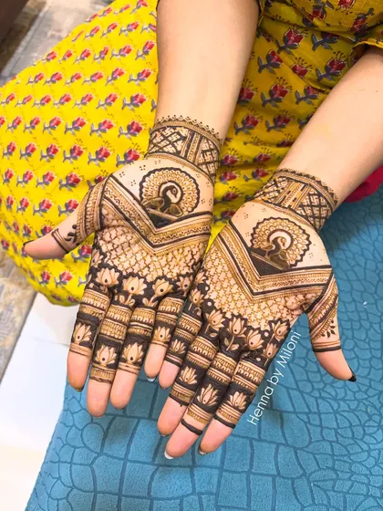 A beautiful guest mehendi with a central peacock motif and lotus patterns on the fingers.