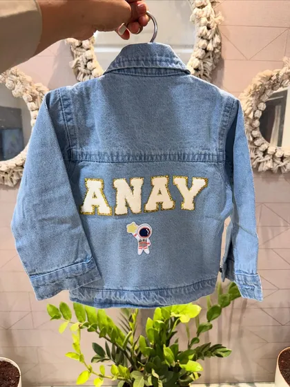 This personalized denim jacket with the name 'ANAY' and an astronaut patch is a super cool and unique gift for a little boy.