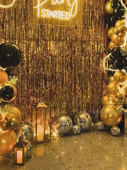 A close-up on the details of the black and gold setup, showing the lantern lights and disco balls scattered at the base, adding warmth and a fun, retro vibe.