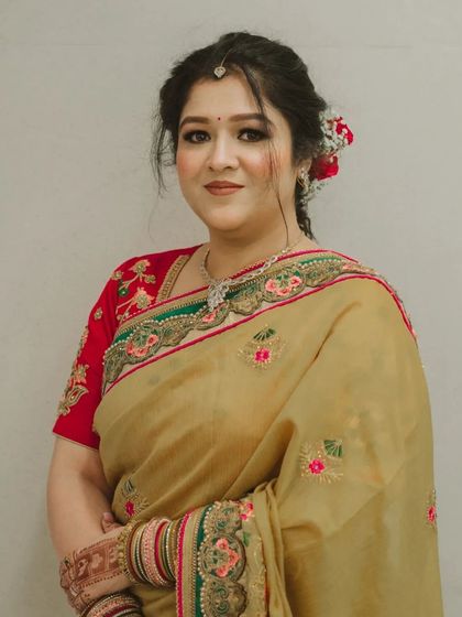 A front-facing portrait showing the delicate details of the makeup and the floral hair accessory.