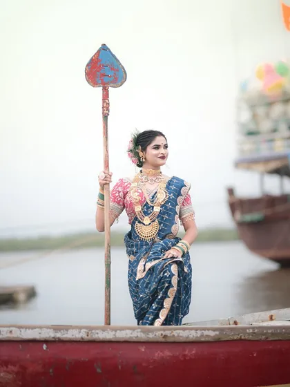 Standing tall in the boat, this shot captures the strength and grace of the Koli women.