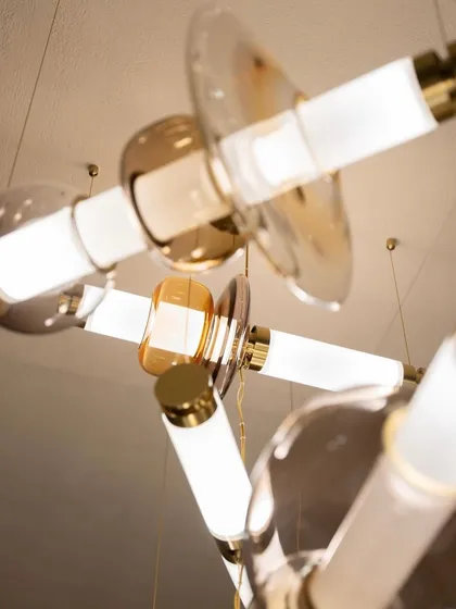 An upward view into a complex Luna chandelier installation captures the dynamic arrangement of its glowing tubes and glass forms. This perspective showcases the fixture's three-dimensional, sculptural quality.
