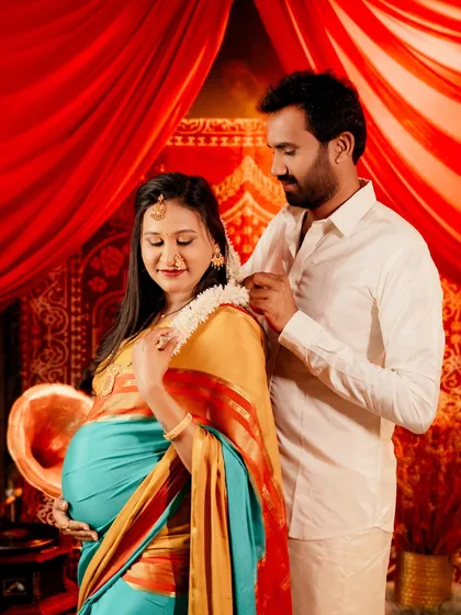A beautiful moment of care and tradition, as the partner adorns the mom-to-be with a gajra flower garland. This highlights the couple's shared journey in the pregnancy photoshoot.