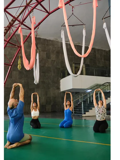 A Vayu Yoga class begins with synchronized stretches on the mat, led by our instructor, to prepare the body and mind for the aerial practice ahead.