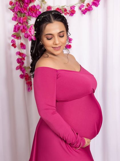 A beautiful close-up portrait against a vibrant floral backdrop, highlighting her serene expression and the details of her hairstyle.