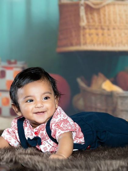 A happy baby crawling on the rug, with the hot air balloon backdrop creating a sense of adventure.