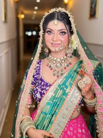 A close-up of the colorful bride. The makeup features a pop of pink blush and a soft, shimmery eye to match the festive feel of the outfit.