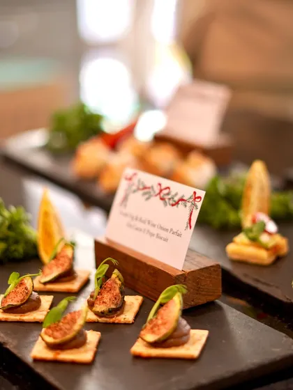 A sophisticated bite of creamy fig and red wine onion parfait on a crisp biscuit. This canapé combines sweet and savory flavors, showcasing our creative approach to finger foods for high-end events.