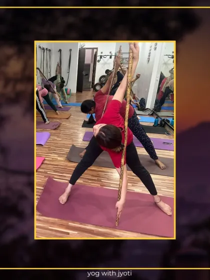 A student uses a stick to maintain alignment and deepen the twist in Trikonasana (Triangle Pose).