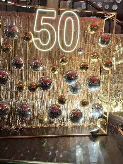 Another perspective of the grand 50th-anniversary installation. The structured frame adds a modern architectural element to the free-flowing glitter of the fringe and disco balls.