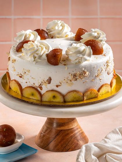 A modern take on a classic Indian dessert, this Gulab Jamun cake is topped with whipped cream and whole gulab jamuns.