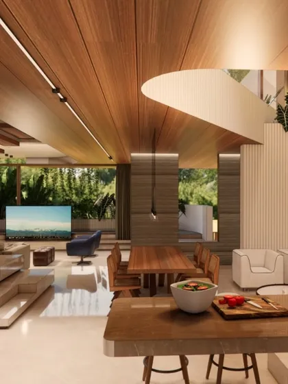 This open-plan living and dining space is from a 60x40 residence. My goal was to create a warm, expansive area for family life, using a rich wood-paneled ceiling and floor-to-ceiling glass to connect the interior with the surrounding greenery.