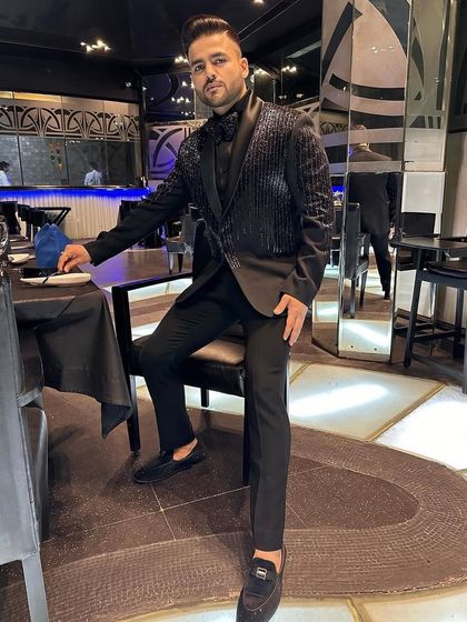 The same vertically striped tuxedo, seen from a different angle. The all-black ensemble is the epitome of cool sophistication.