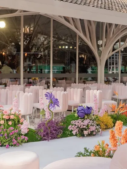 The ceremony seating viewed from the side, showing the beautiful floral arrangements that line the aisle and the elegant architecture of the venue.