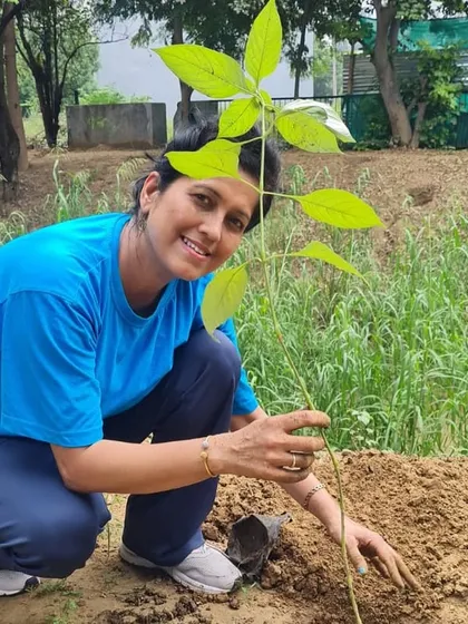 A smiling volunteer from NTT DATA proudly poses with the sapling she has just planted. These drives are not just about work; they are about finding joy and purpose in giving back to the environment.