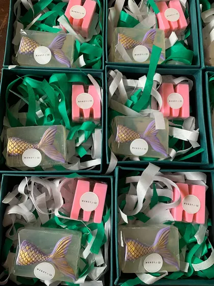A unique mermaid gift set featuring a clear glycerin soap with an embedded mermaid tail and a personalized initial soap.