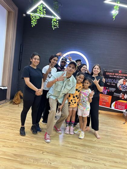 The whole group, including kids and adults, posing with the guest instructor after a successful workshop.