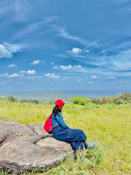 A trekker sitting on a rock, enjoying the solitude and the beautiful view.