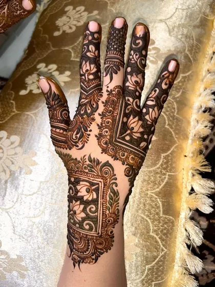 A beautiful siders design featuring lotus motifs within a square frame, covering the side of the hand and fingers.