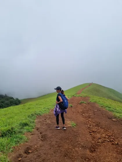 A solo trekker taking in the view along the Nethravathi ridge. The path is well defined, making it a great trek for building confidence while enjoying the scenery.