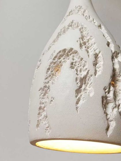 A close-up of the textured ceramic pendant, showing the intricate, carved details that make this light so special.