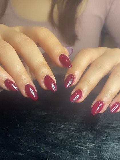 A full view of the classic wine-red manicure.