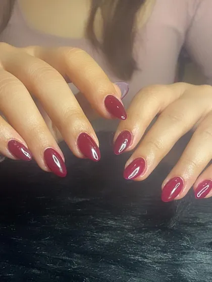 A full view of the classic wine-red manicure.
