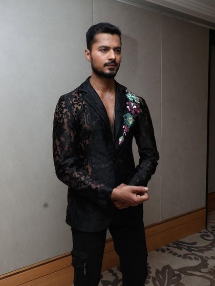 A three-quarter shot of the designer lace blazer, showing the intricate details and fit.