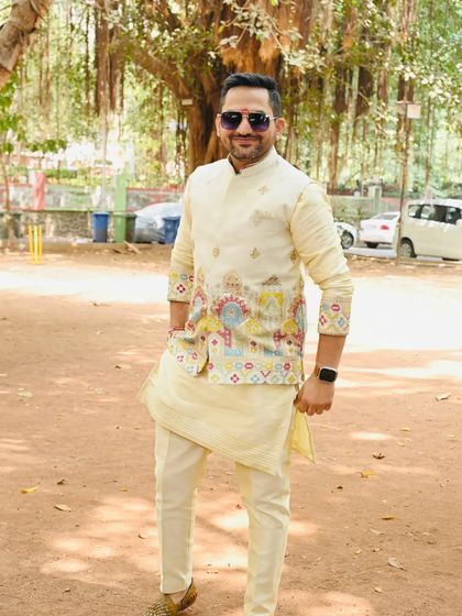 A full-length view of the ivory kurta with the embroidered organza jacket. The unique design on the jacket makes it a statement piece for any celebration.