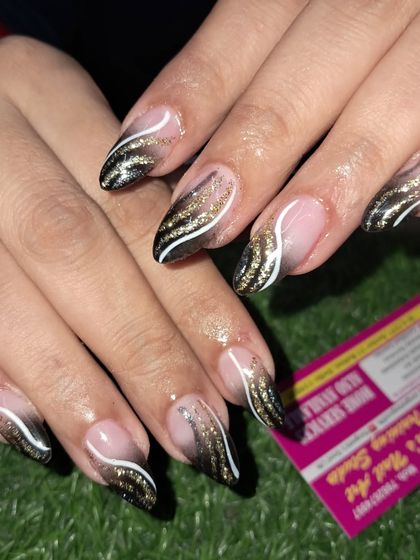 A close-up of this dramatic black and gold glitter ombre nail art.