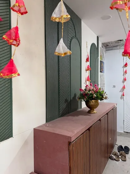 Simple yet charming decor elements, like these hanging fabric tassels and a single floral arrangement, can transform any corner of a home for a Mehendi function.