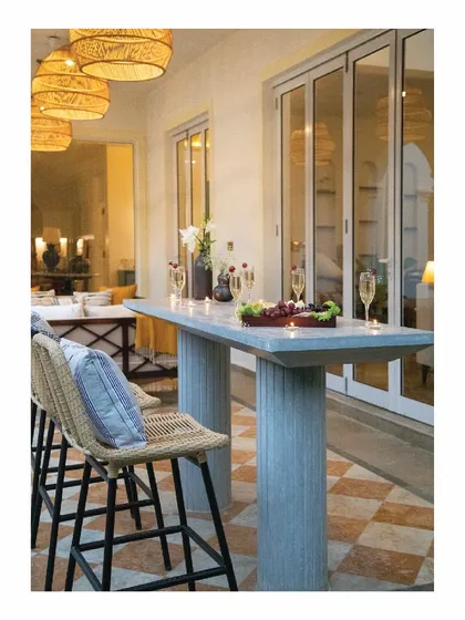A cast in-situ bar table in grey concrete sets the mood for this verandah sit-out. Paired with cane chairs and matching hanging lights, it becomes a relaxed and stylish spot for enjoying the tropical evenings by the pool.