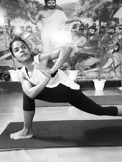 A student demonstrates Parivrtta Parsvakonasana (Revolved Side Angle Pose). This deep twisting lunge detoxifies the organs, improves balance, and builds immense strength.