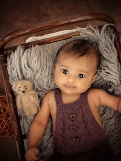 Even in a more rustic setup, we can capture beautiful awake moments. This baby is looking directly at the camera, giving us a glimpse of his calm and gentle personality.